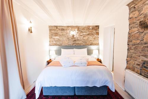 斯奇博瑞恩Stone Barn的卧室配有白色的床铺和石墙