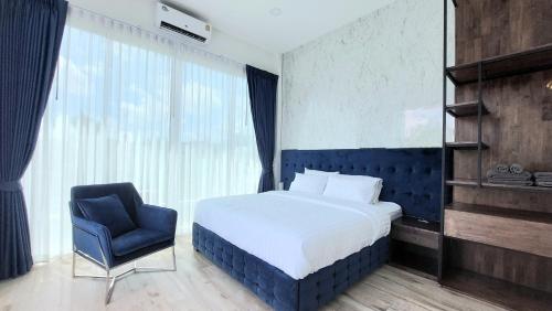 Bang KrasopGreen Lung Pool Villas Bangkok的一间卧室配有一张床和一张蓝色椅子