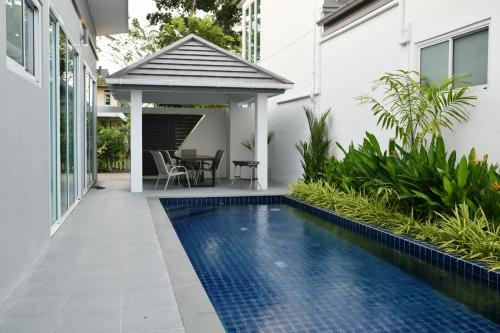 Bang KrasopGreen Lung Pool Villas Bangkok的一座带凉亭的房子前的游泳池