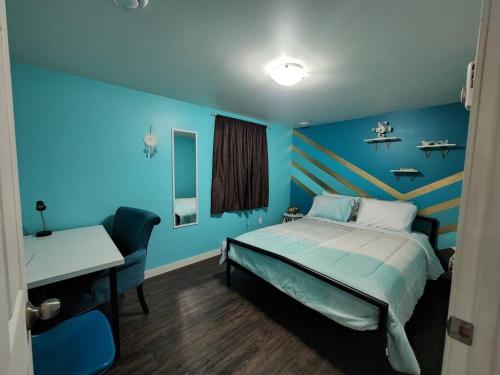 萨斯卡通TheAuroras: Vibrant&Cheerful 2 bdrm Stylish suite的蓝色客房 - 带一张床和一张书桌