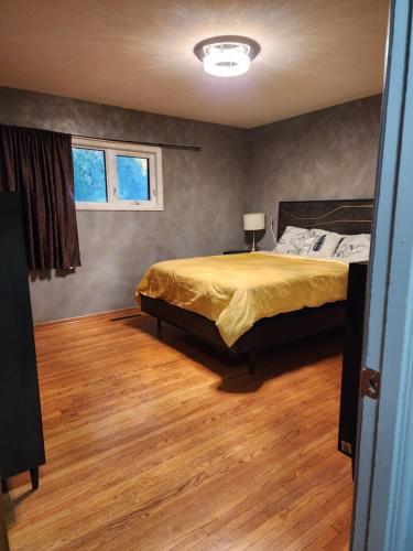 萨斯卡通TheSunshine: Bright&Peaceful 2 Bdrm Character Home的一间卧室配有一张床,铺有木地板