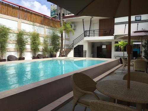 土格加劳卡梅利塔酒店 的一个带椅子和桌子的游泳池以及一把遮阳伞