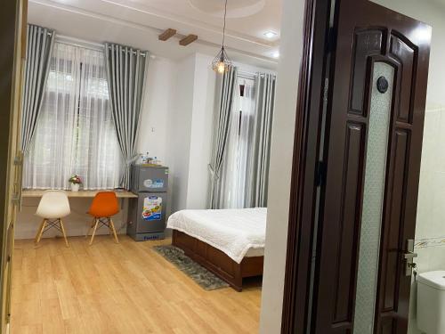 岘港Lu Peaceful Homestay的一间卧室配有一张床、一张桌子和一把椅子