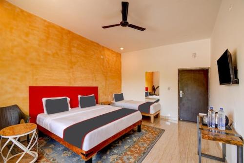 ChandrāvatiRoyal Casa - Asra Hotel的酒店客房设有两张床和电视。