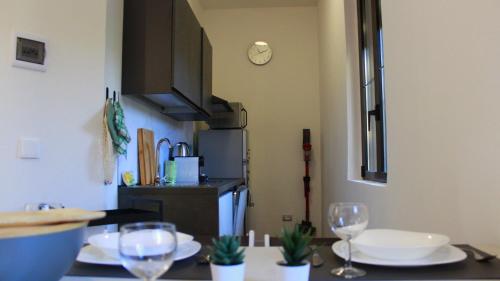 塞斯托卡伦德Lago Maggiore Lake Me Home apartment的厨房配有带盘子和酒杯的桌子