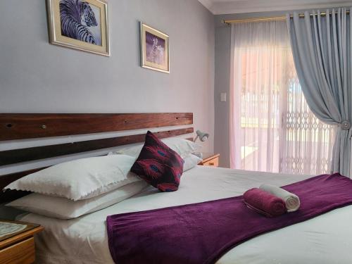 金伯利阿格洛斯宾馆的一间卧室配有一张大床和枕头