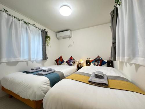 东京nestay villa tokyo sugamo的两张睡床彼此相邻,位于一个房间里