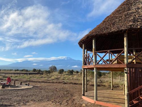 安博塞利Amboseli Discovery Camp的茅草屋顶的小屋