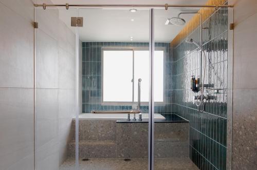合艾Buri Sriphu Hotel & Convention Centre的一间带玻璃淋浴和水槽的浴室