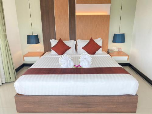 帕他仑斯沃皇家酒店的卧室配有带红色枕头的大型白色床