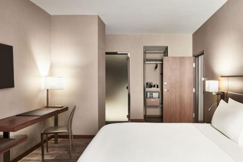 新奥尔良AC Hotel by Marriott New Orleans French Quarter的配有一张床和一张书桌的酒店客房