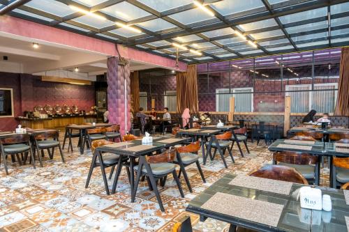 直葛Premiere Hotel Tegal的餐厅设有桌椅,背景人员