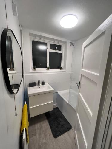 伦敦a two bedroom cosy hideaway based in greenwich的白色的浴室设有水槽和浴缸。