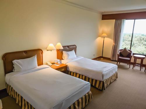 Ban Ru Sa Mi Laeโรงแรม ซี.เอส. ปัตตานี的酒店客房设有两张床和窗户。