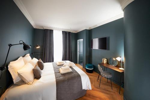 瓦朗斯Hotel Victoria的一间卧室配有一张床、一张书桌和一台电视