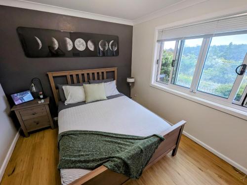 GlenbrookLunar Escape的一间卧室设有一张床,墙上设有窗户和时钟。