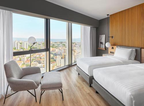 斯普利特AC Hotel by Marriott Split的酒店客房,配有两张床和椅子
