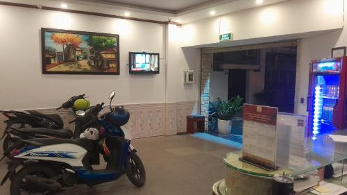 河内A25 Hotel - Đội Cấn 1的停在墙上的一张照片的房间的摩托车