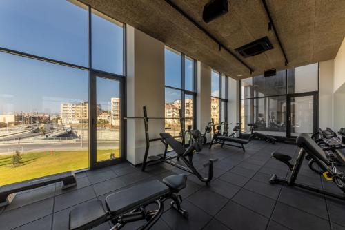 瓦尔纳Hotel Campus 90 - Free Parking的一个带跑步机和椭圆机的健身房,位于一栋带窗户的建筑内