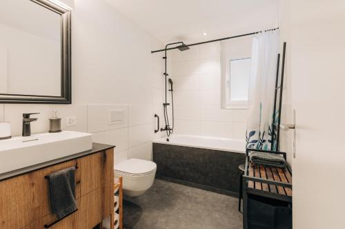 阿德尔博登Chuenislodge1 Neu, grosse Terrasse & Designerofen, prächtige Aussicht的浴室配有盥洗盆、卫生间和浴缸。