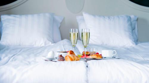 林雪平林柯平弗缇塔公园酒店的床上的托盘,包括两杯香槟和水果
