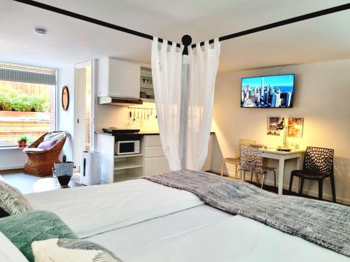 哥本哈根Neptun Studio-apartment with terrace.的一间带白色床的卧室和一间厨房