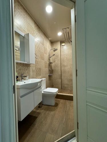 巴统Iko's Family Apartments的浴室配有卫生间、盥洗盆和淋浴。