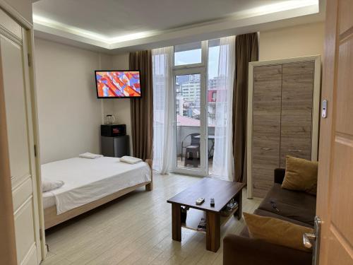 巴统Iko's Family Apartments的酒店客房配有床、沙发和电视。