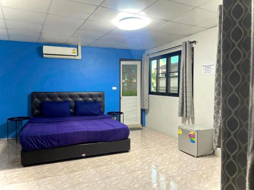 曼谷U&D guest house的一间蓝色墙壁上带紫色床的卧室