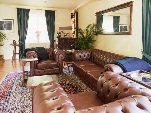 劳森伯格BnB Rauschenberg的客厅配有棕色皮革家具和镜子