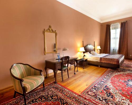 SzprotawaPałac Wiechlice - Hotel, Restaurant, SPA的一间卧室配有一张床、一张书桌和一面镜子