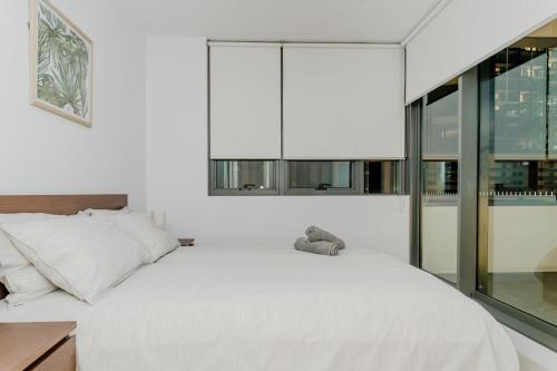悉尼Modern 2 Bedroom Apartment Darling Square的卧室配有一张大白色床和窗户