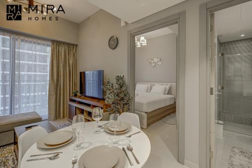 迪拜Mira Holiday Homes - Lovely 1 bedroom in Business Bay的一间带餐桌的客厅和一间卧室