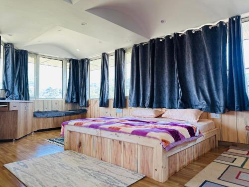达兰萨拉Dhauladhar Homes的一间卧室配有一张带黑色窗帘的木床