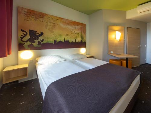 魏玛威玛住宿加早餐旅馆的卧室配有一张大床,墙上挂有绘画作品