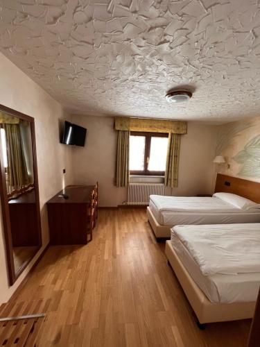 布勒伊-切尔维尼亚Hotel Breuil的客房设有两张床和一张书桌