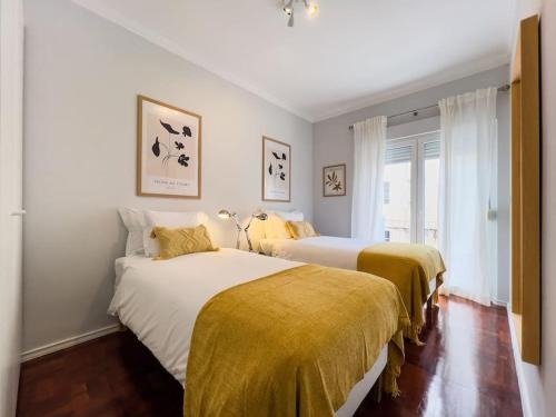 里斯本Olaias Lisbon 2bed near Metro的一间卧室配有两张带黄色毯子的床