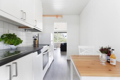 蒂瑟达尔Trolltunga Aparthotel的厨房配有白色橱柜和木制台面