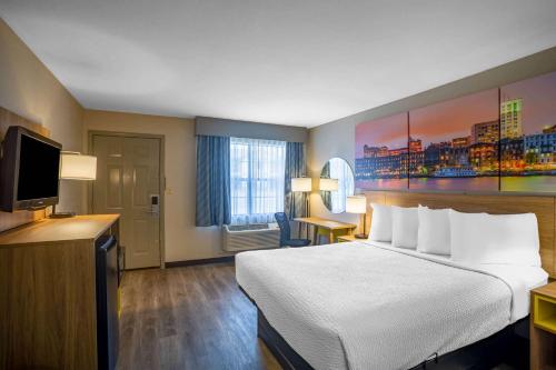 Lonoke洛诺克戴斯旅馆的配有一张床和一台平面电视的酒店客房