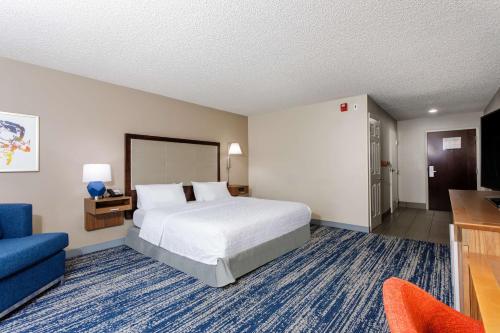 泰特斯维尔泰特斯维尔/I-95州际公路肯尼迪航天中心汉普顿酒店的酒店客房,配有床和蓝色的沙发