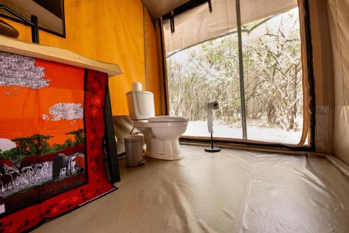 塔勒克Olkinyei Mara Tented Camp的一间带卫生间和窗户的浴室