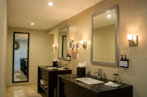 圣萨尔瓦多Hilton San Salvador的一间带两个盥洗盆和大镜子的浴室