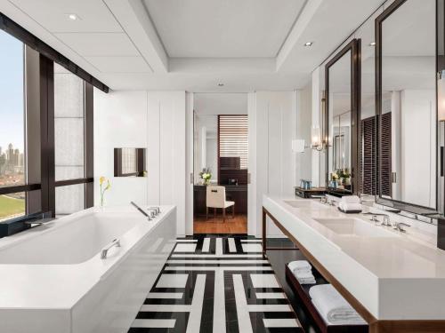 武汉武汉泛海费尔蒙酒店的浴室配有2个盥洗盆和1个浴缸。