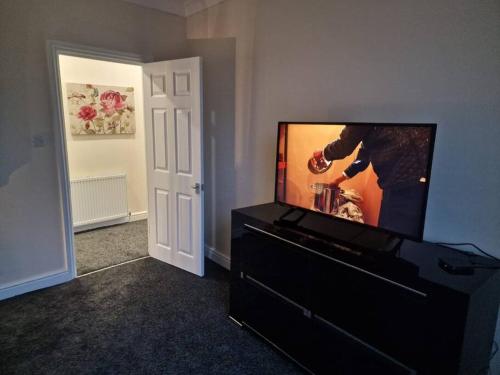 达灵顿Levy Nook 4的客厅配有梳妆台上的平面电视