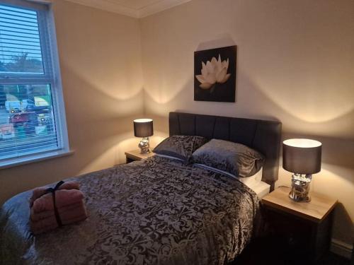达灵顿Levy Nook 4的一间卧室配有一张带两盏灯的床和一扇窗户。