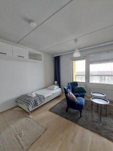 万塔Kotimaailma - Avara ja valoisa studio Vantaalla的客厅配有床和蓝椅