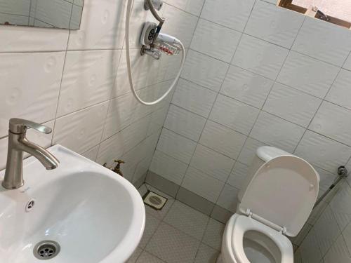 NamugongoTwinkle Blue Inn的白色的浴室设有水槽和卫生间。