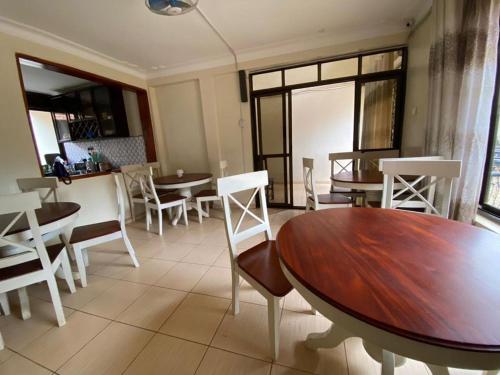NamugongoTwinkle Blue Inn的用餐室配有桌子和白色椅子