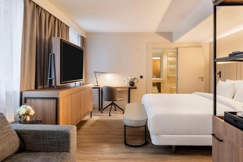 阿姆斯特丹NH Amsterdam Leidseplein的一间酒店客房,配有一张床和一台电视