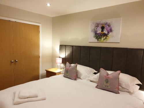 大圣科勒姆Peaceful relaxing home with leisure的卧室配有带粉红色枕头的大型白色床